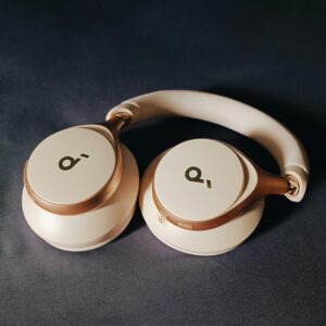 Modern beige wireless headphones on a dark surface, perfect for tech lovers.